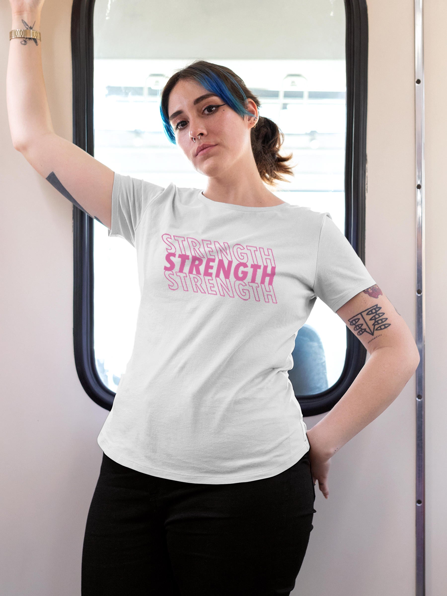 Model wearing Women's White Round Neck T-shirt with 'Strength' design, offering effortless style and premium comfort