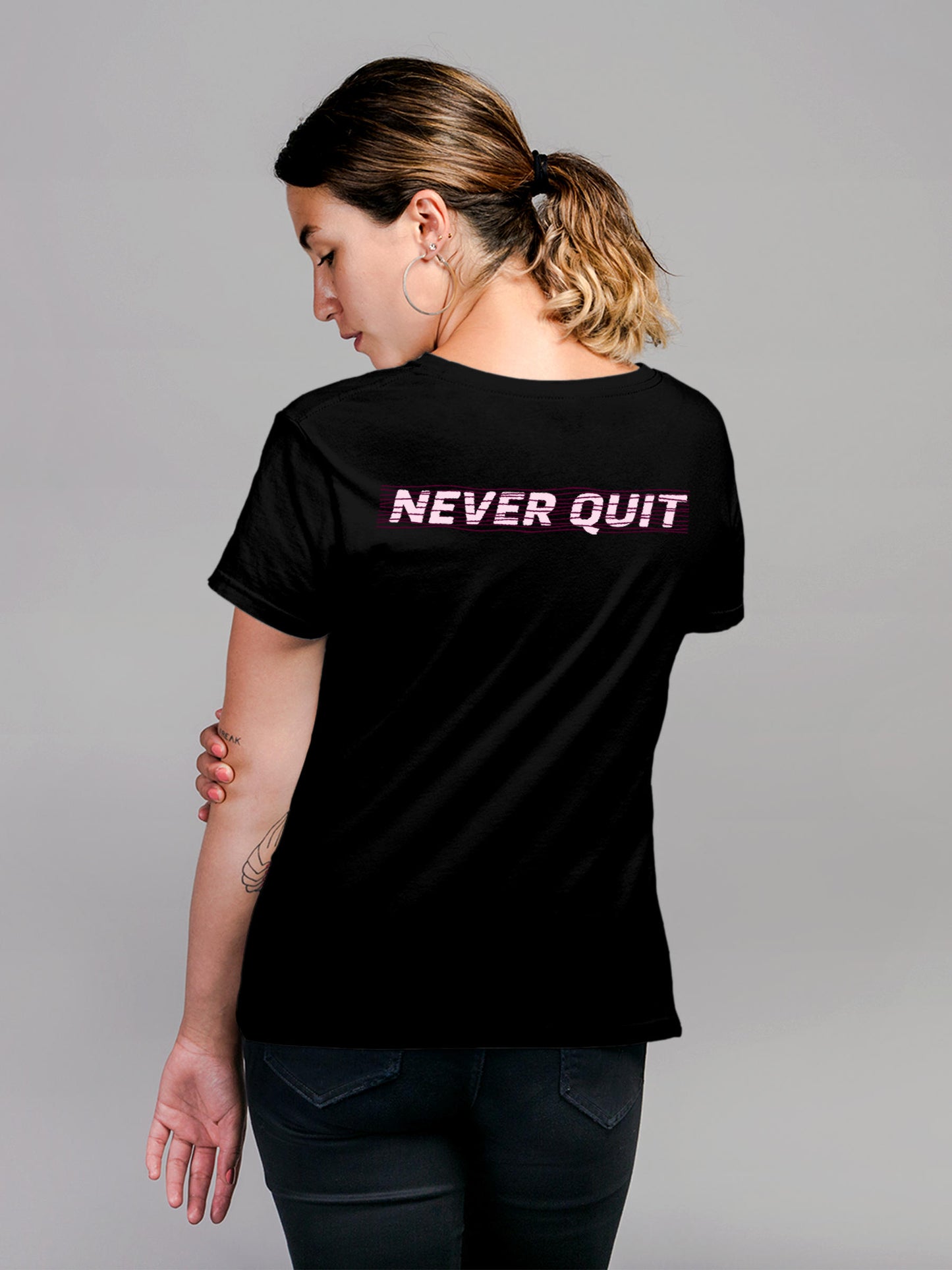 Model wearing Women's Black Round Neck T-shirt with 'Never Quit' design, offering effortless style and premium comfort