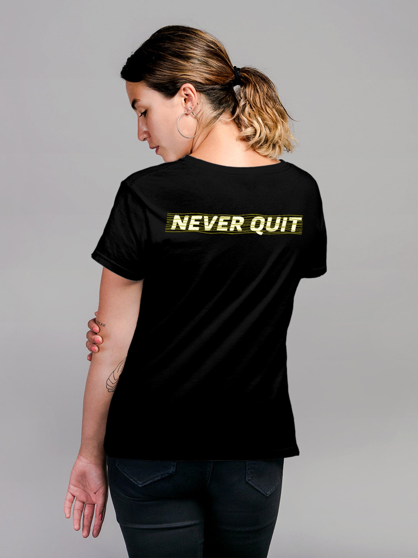 Model wearing Women's Black Round Neck T-shirt with 'Never Quit' design, offering effortless style and premium comfort