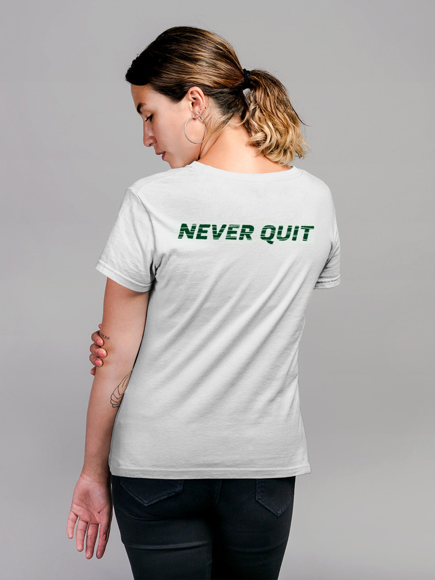 Model wearing Women's White Round Neck T-shirt with 'Never Quit' design, offering effortless style and premium comfort