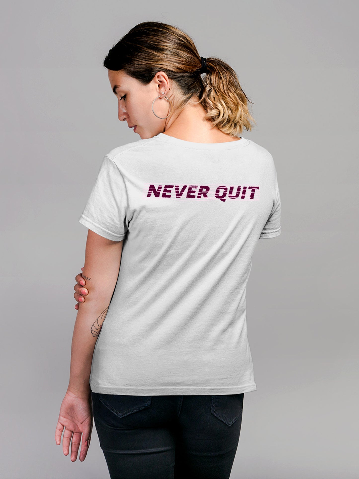 Model wearing Women's White Round Neck T-shirt with 'Never Quit' design, offering effortless style and premium comfort