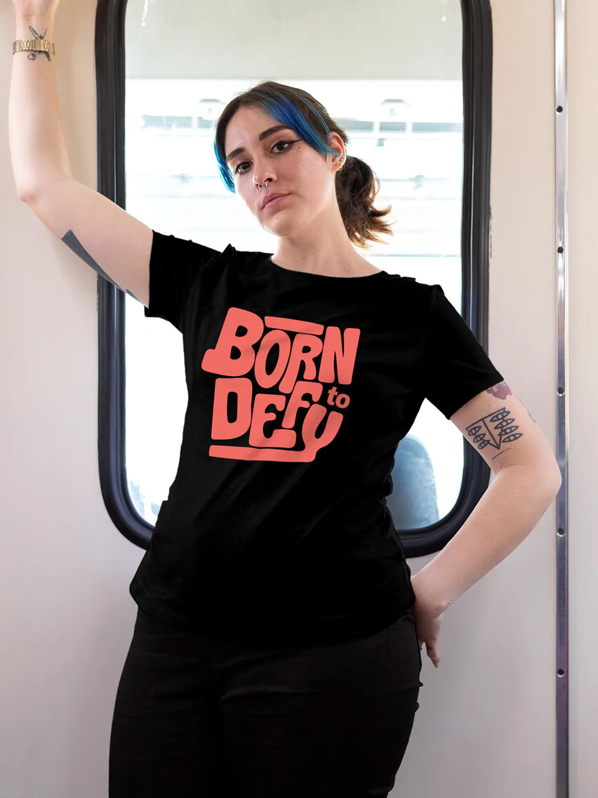Model wearing Women's Black Round Neck T-shirt with 'Born To Defy' design, offering effortless style and premium comfort