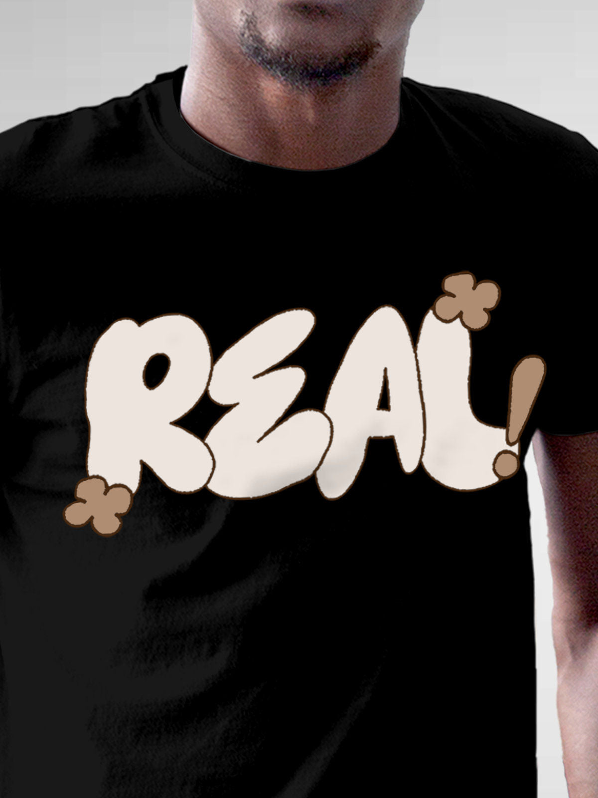 Close up of 'Real' design on Men's Black Round Neck T-shirt, highlighting intricate details and vibrant print.