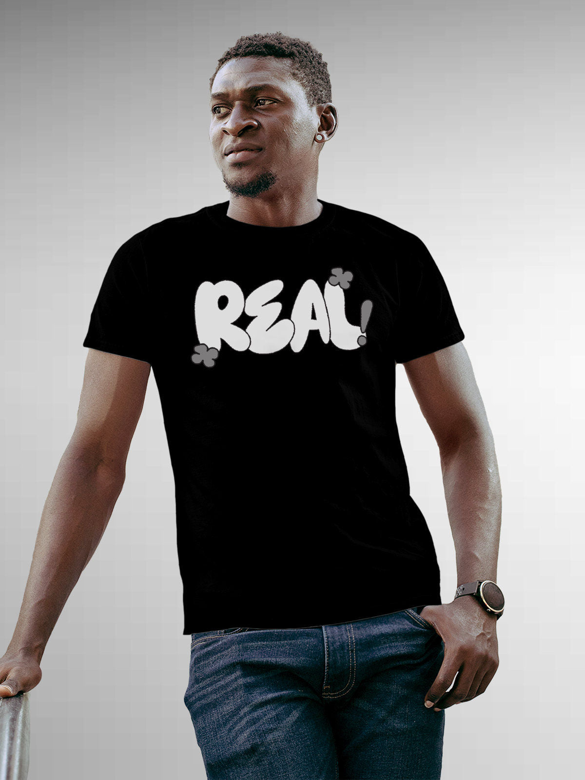 Model wearing Men's Black Round Neck T-shirt with 'Real' design, offering effortless style and premium comfort