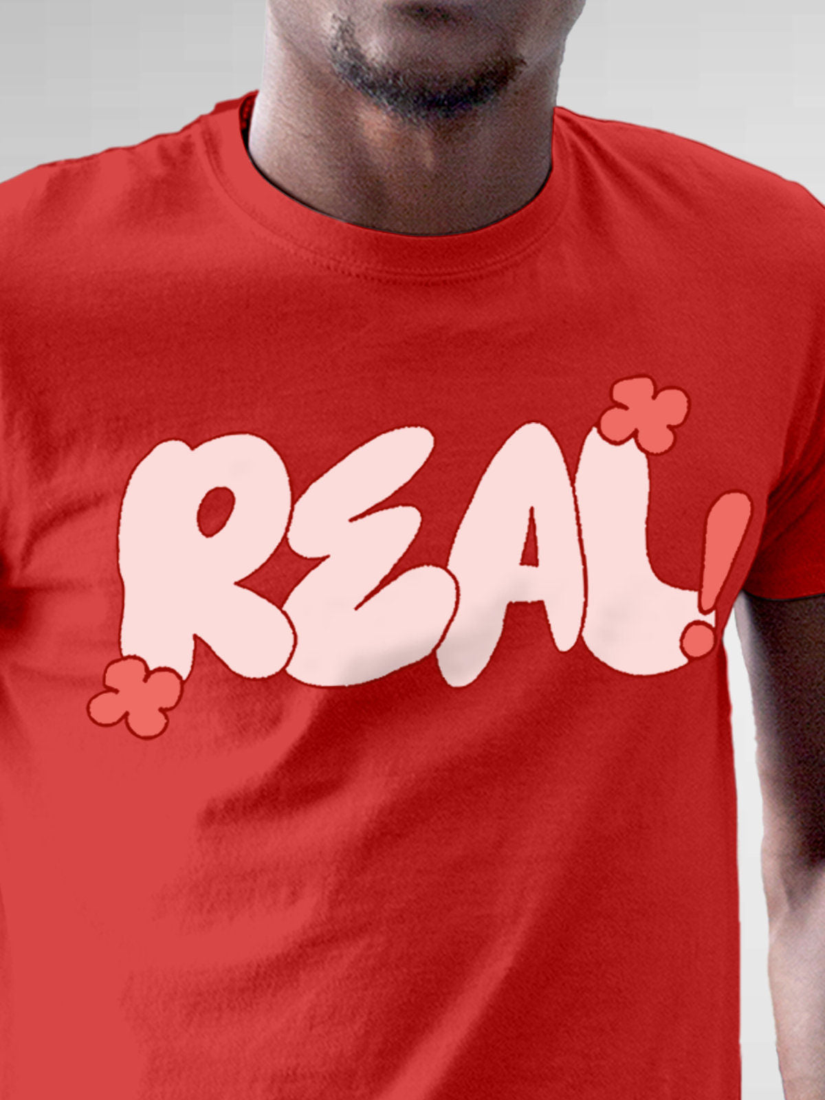 Close up of 'Real' design on Men's Red Round Neck T-shirt, highlighting intricate details and vibrant print.