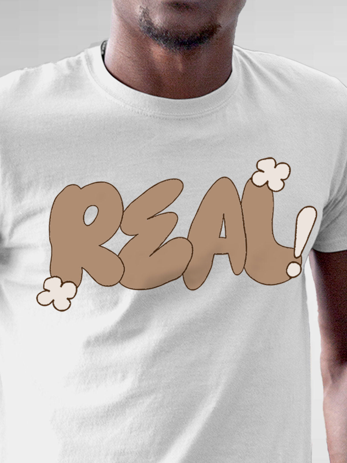 Close up of 'Real' design on Men's White Round Neck T-shirt, highlighting intricate details and vibrant print.