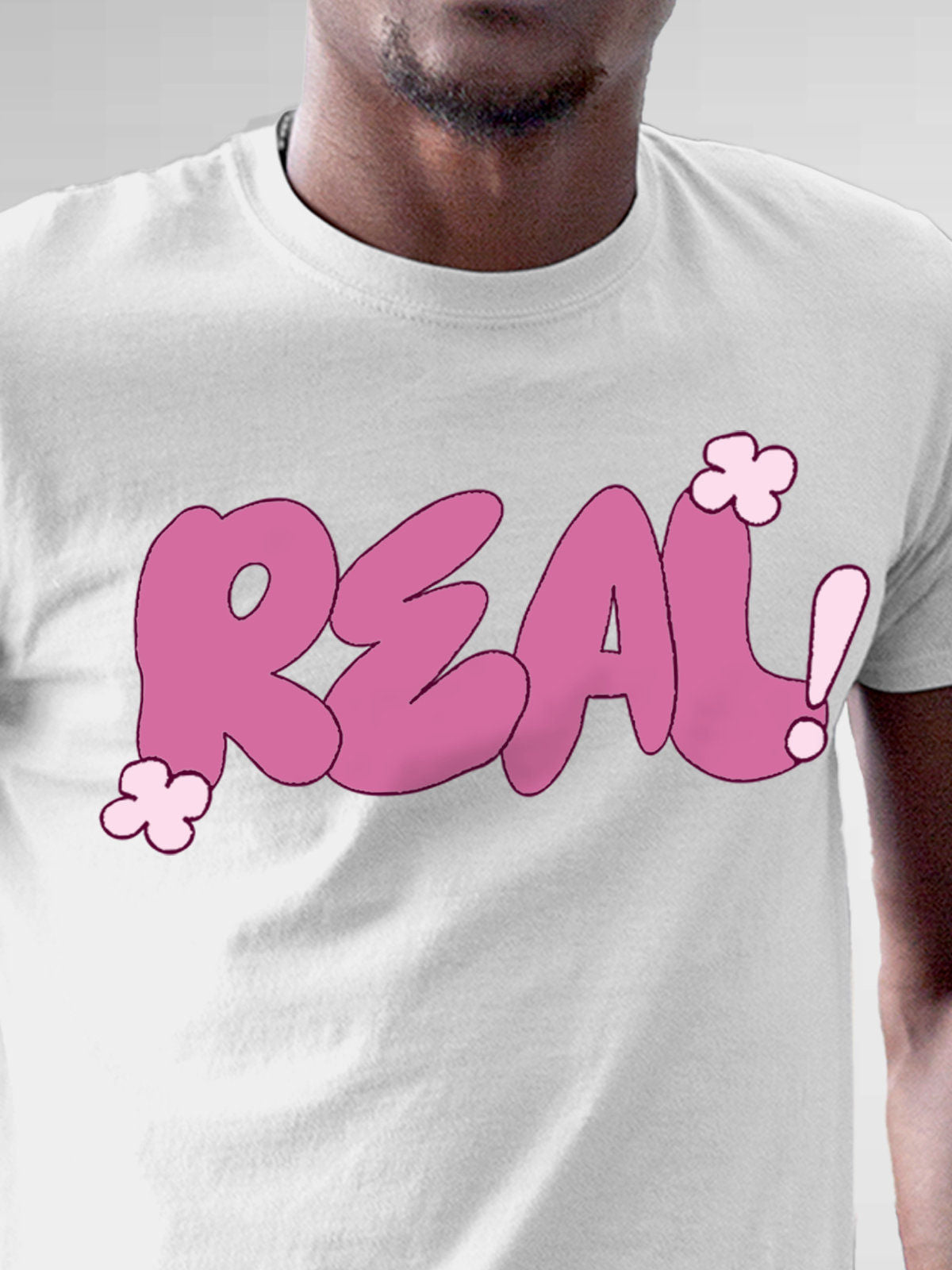 Close up of 'Real' design on Men's White Round Neck T-shirt, highlighting intricate details and vibrant print.
