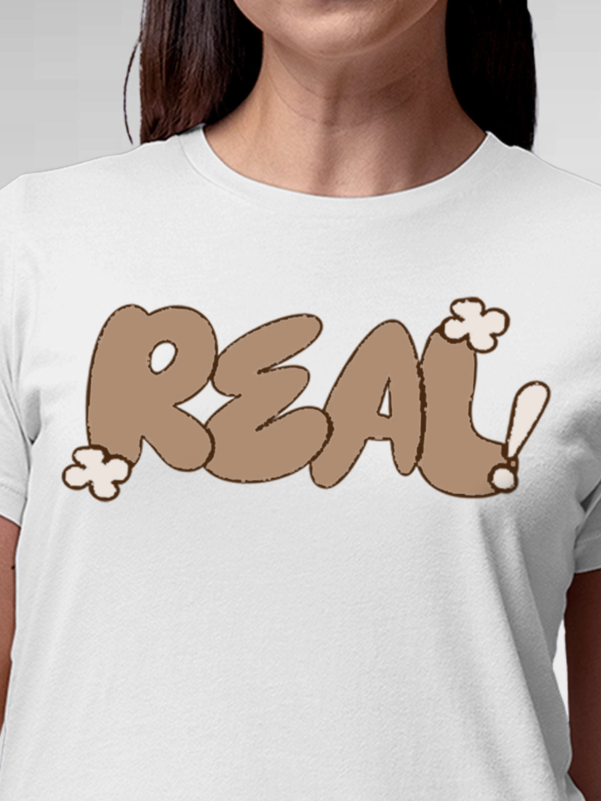 Close up of 'Real' design on Women's White Round Neck T-shirt, highlighting intricate details and vibrant print.