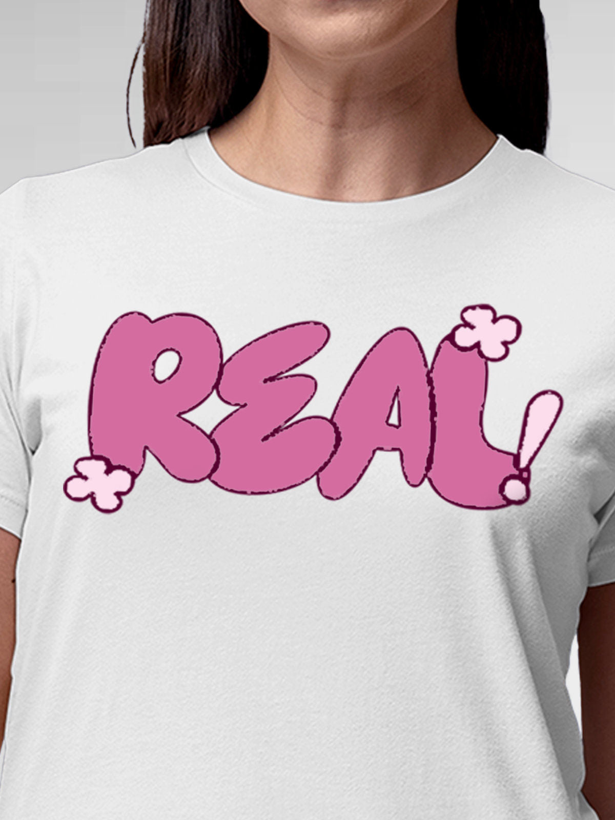 Close up of 'Real' design on Women's White Round Neck T-shirt, highlighting intricate details and vibrant print.