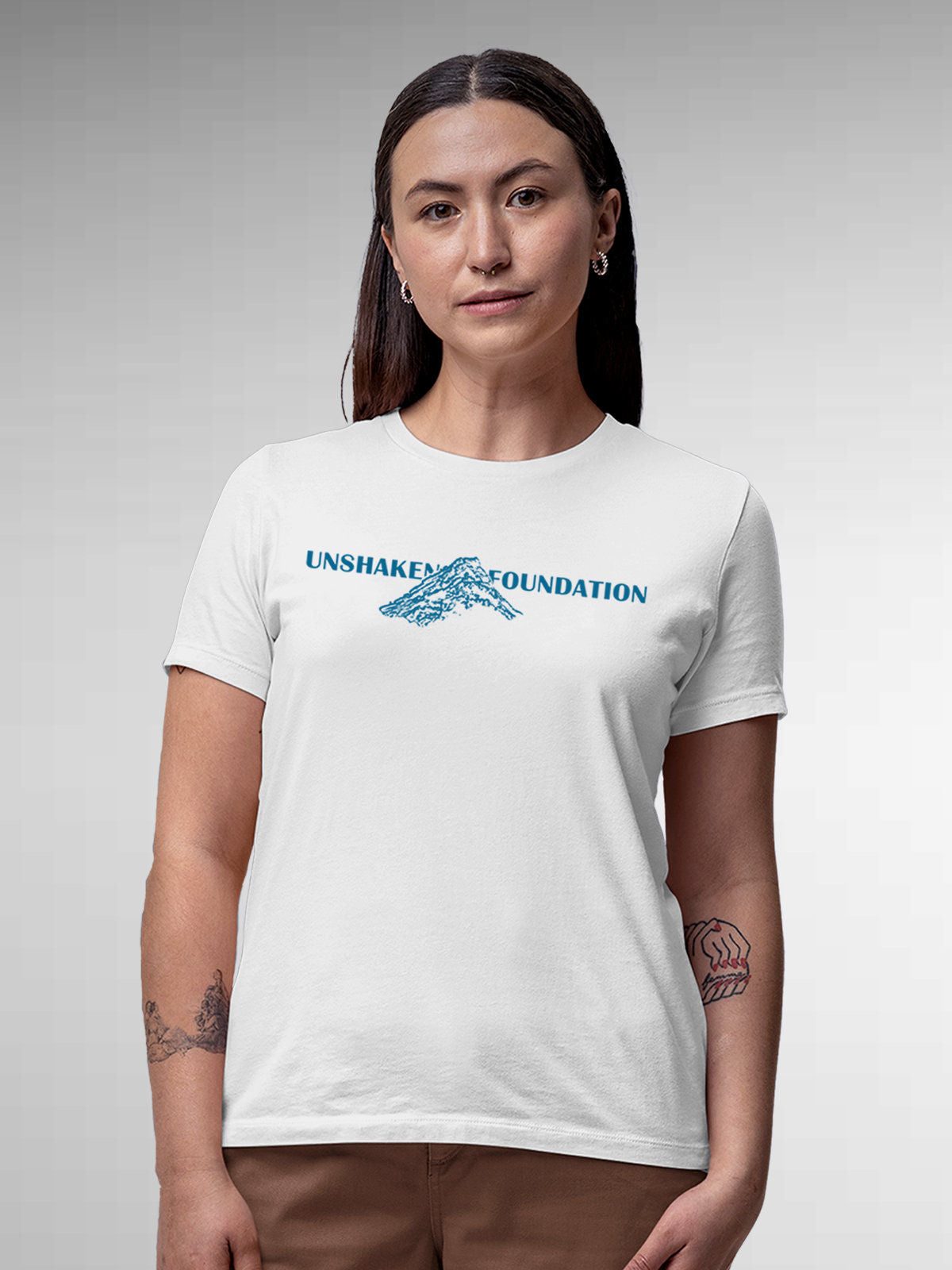 Model wearing Women's White Round Neck T-shirt with 'Unshaken Foundation' design, offering effortless style and premium comfort