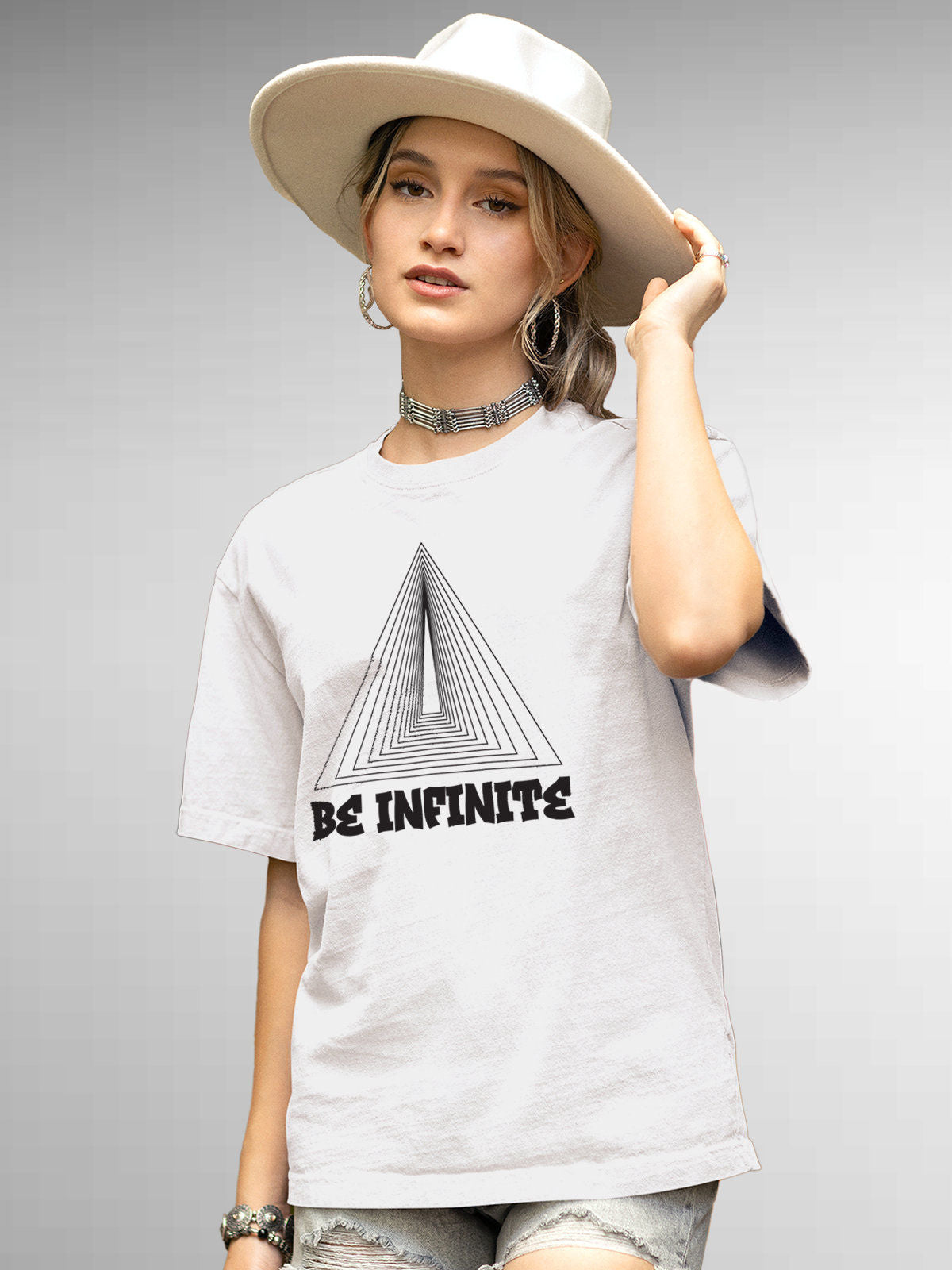 Model wearing Women's White Round Neck T-shirt with 'Be Infinite' design, offering effortless style and premium comfort