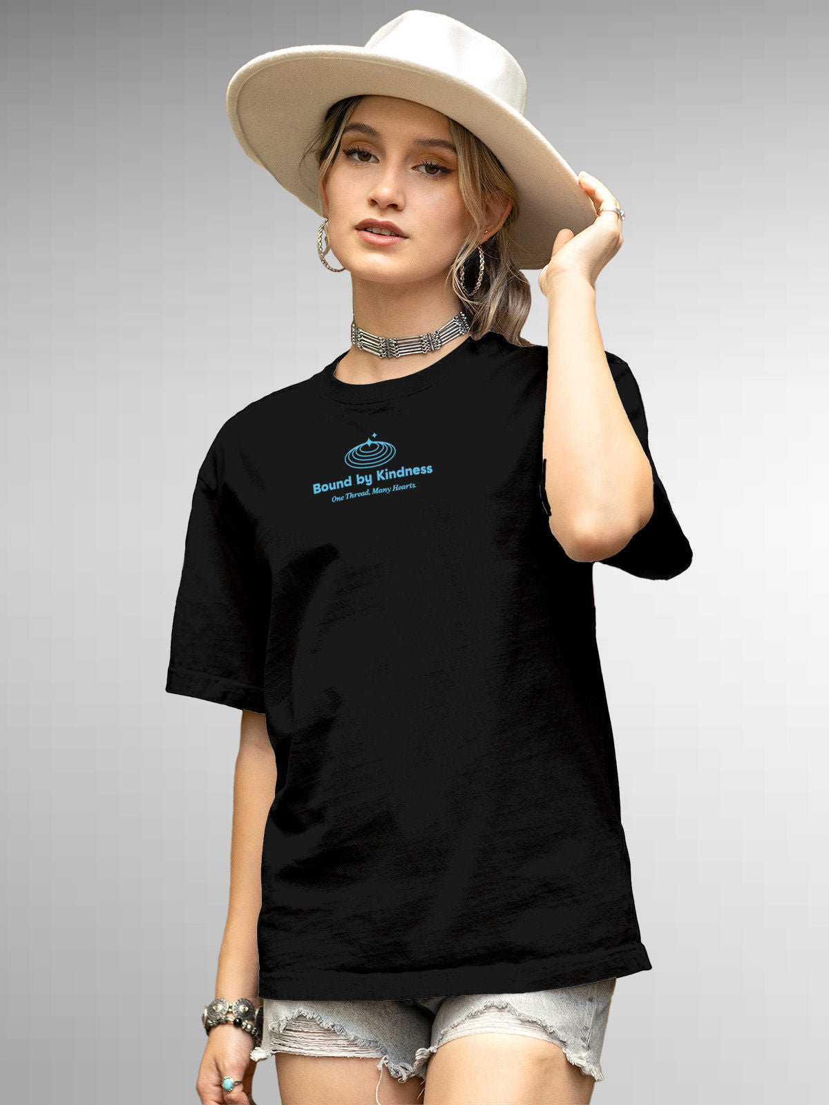 Model wearing Women's Black Round Neck T-shirt with 'Bound By Kindness' design, offering effortless style and premium comfort