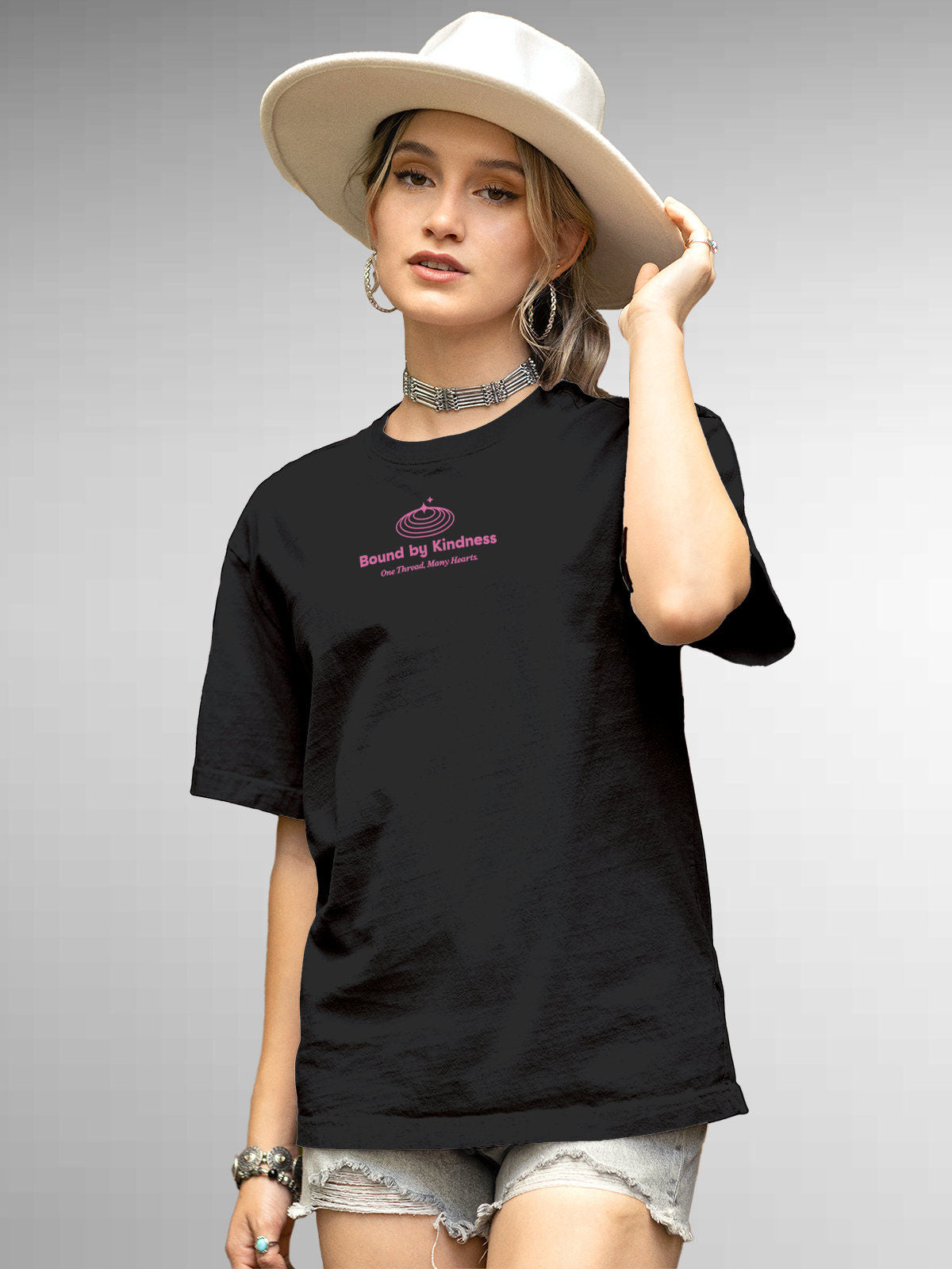 Model wearing Women's Dark Grey Round Neck T-shirt with 'Bound By Kindness' design, offering effortless style and premium comfort