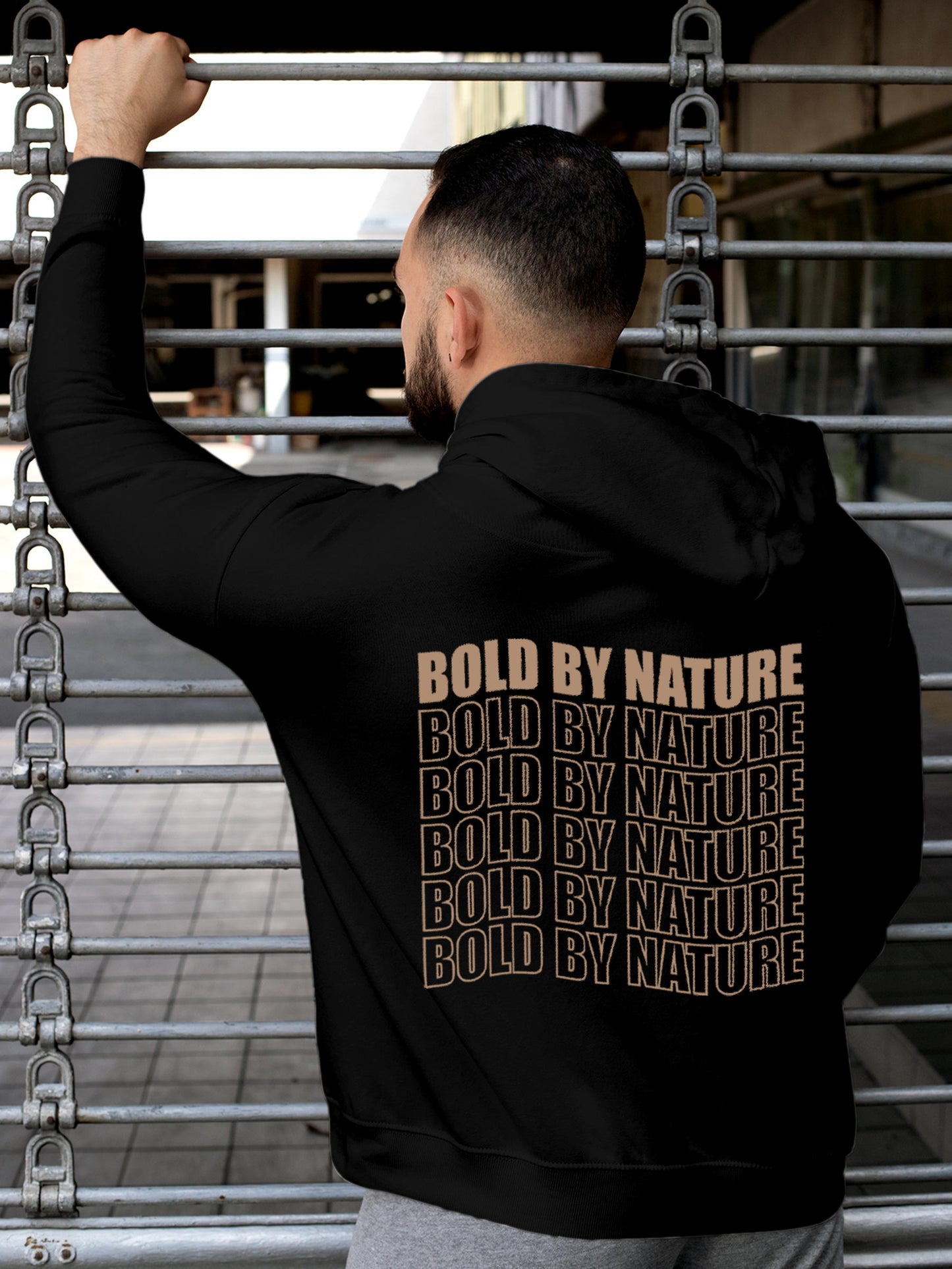 Model wearing Men's Black Hoodie Sweatshirt with 'Bold By Nature' design, offering effortless style and premium comfort