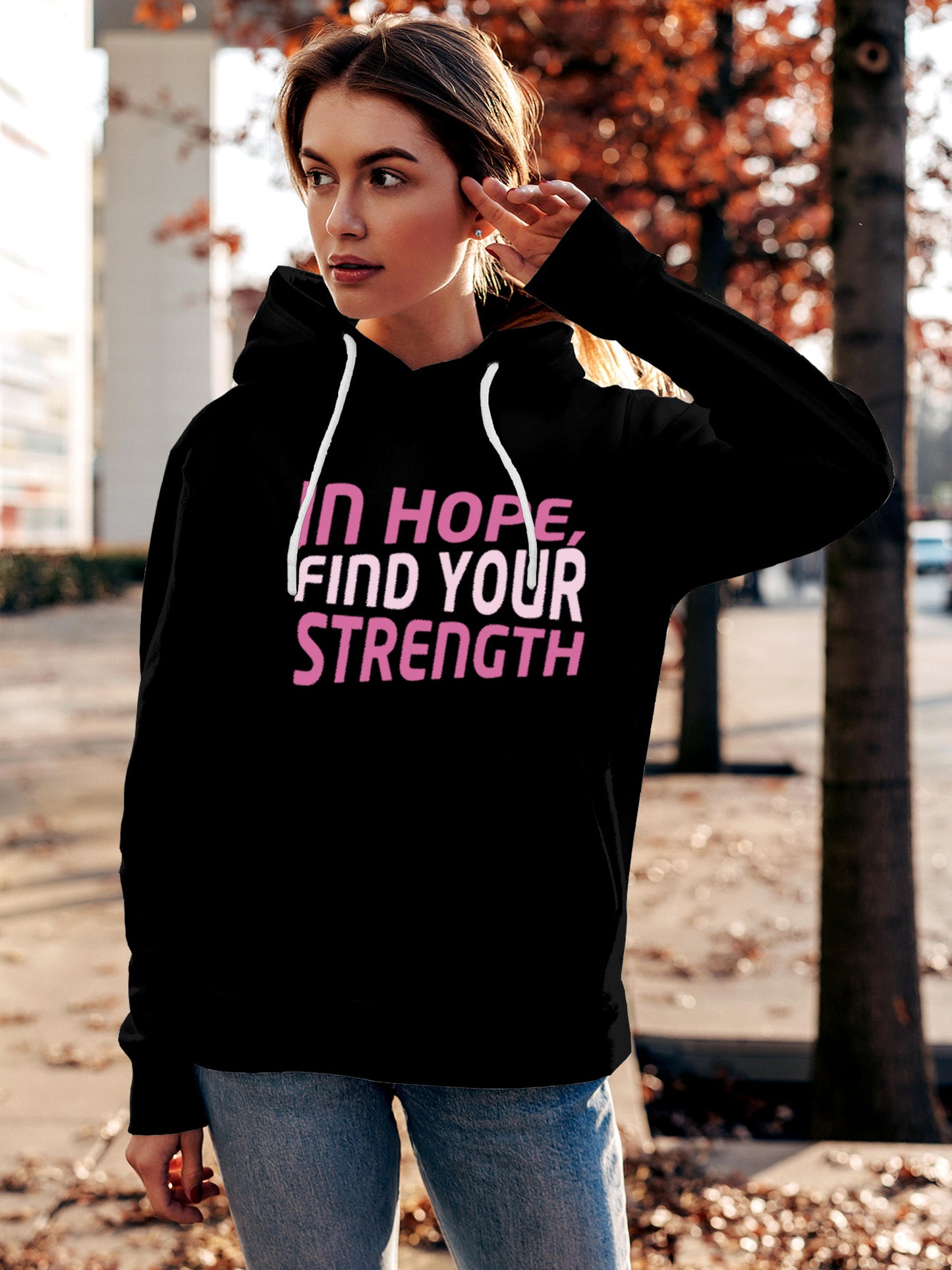 Model wearing Women's Black Hoodie Sweatshirt with 'In Hope, Find Your Strength' design, offering effortless style and premium comfort