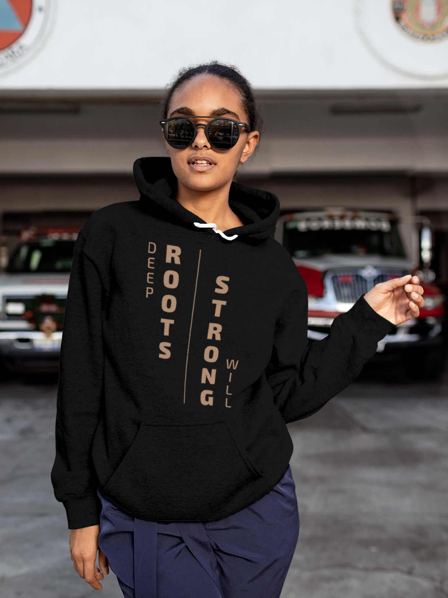Model wearing Women's Black Hoodie Sweatshirt with 'Deep Roots Strong Will' design, offering effortless style and premium comfort