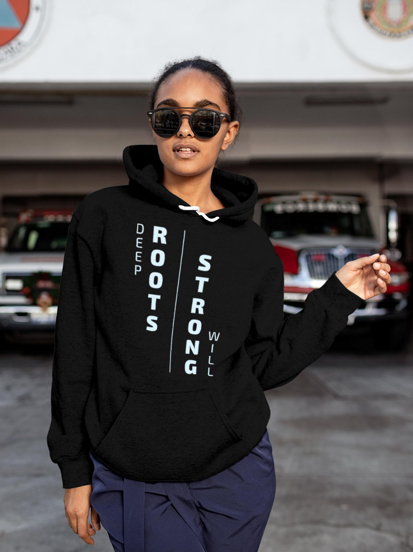 Model wearing Women's Black Hoodie Sweatshirt with 'Deep Roots Strong Will' design, offering effortless style and premium comfort