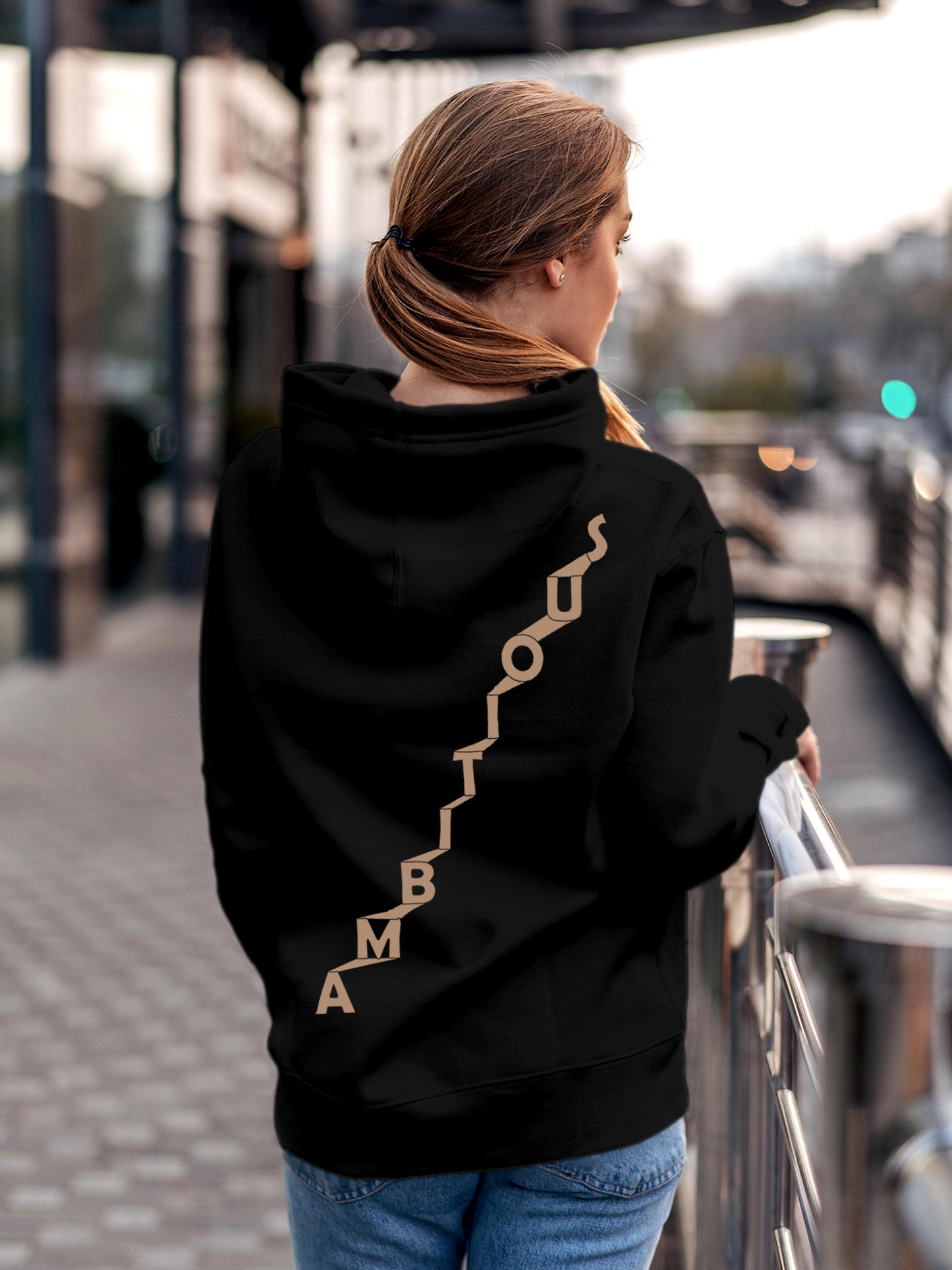 Model wearing Women's Black Hoodie Sweatshirt with 'Ambitious' design, offering effortless style and premium comfort
