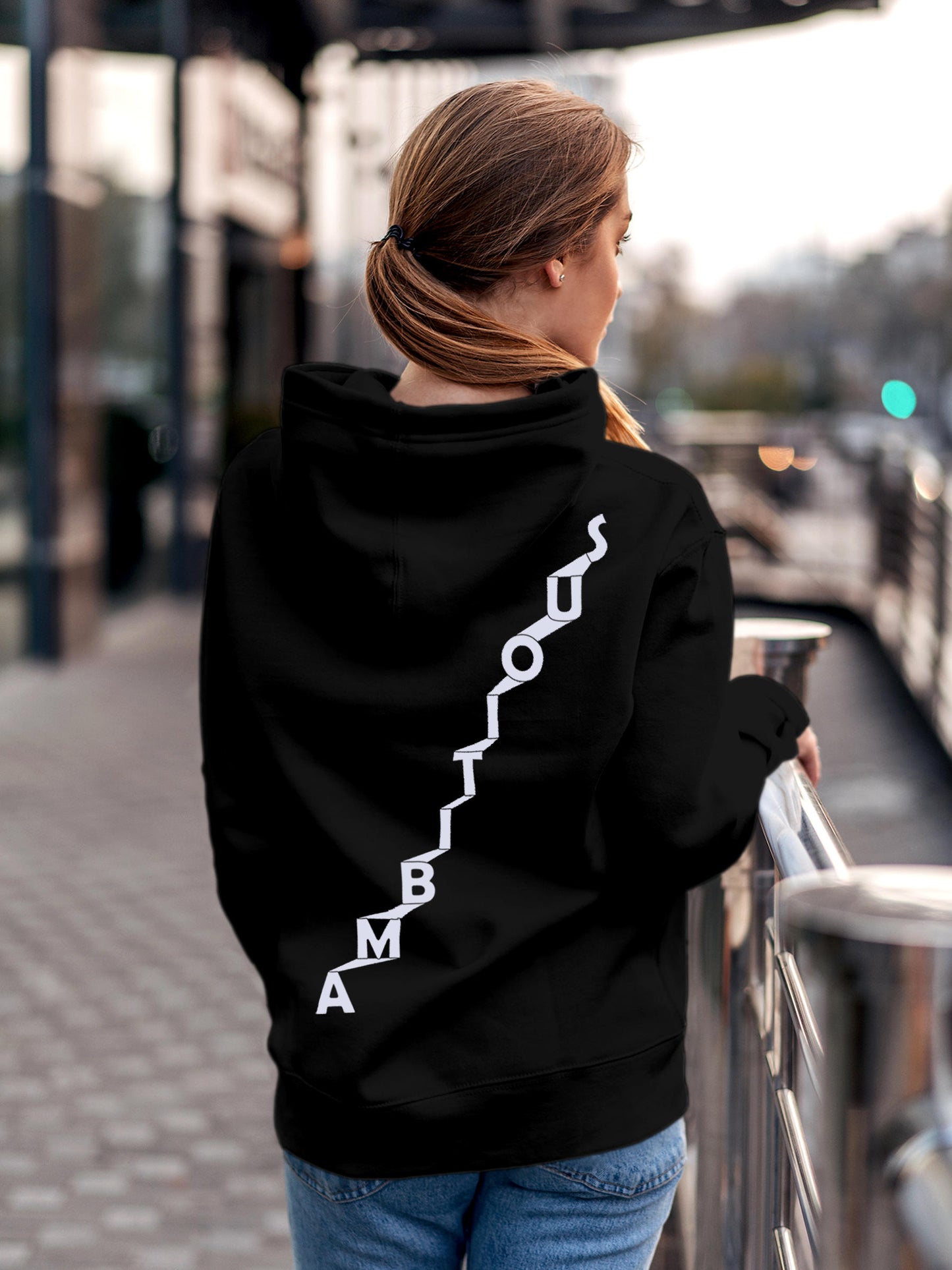 Model wearing Women's Black Hoodie Sweatshirt with 'Ambitious' design, offering effortless style and premium comfort
