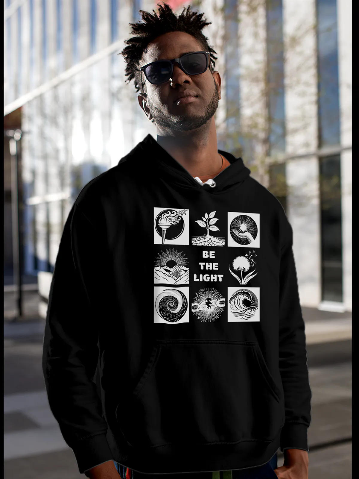 Model wearing Men's Black Hoodie Sweatshirt with 'Be The Light' design, offering effortless style and premium comfort