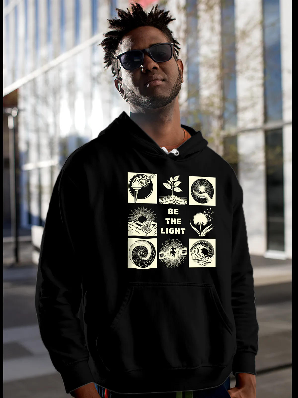 Model wearing Men's Black Hoodie Sweatshirt with 'Be The Light' design, offering effortless style and premium comfort