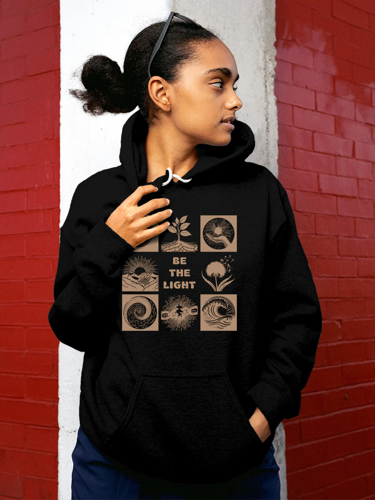 Model wearing Women's Black Hoodie Sweatshirt with 'Be The Light' design, offering effortless style and premium comfort