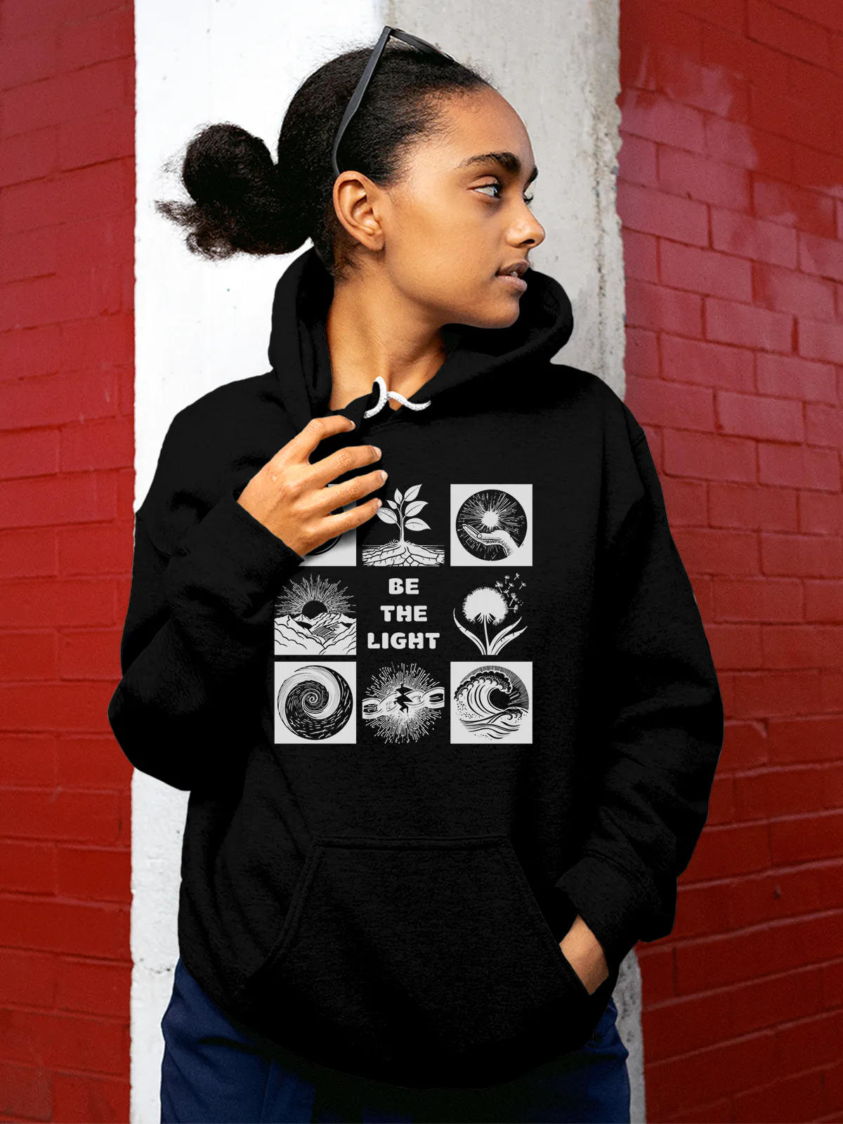 Model wearing Women's Black Hoodie Sweatshirt with 'Be The Light' design, offering effortless style and premium comfort