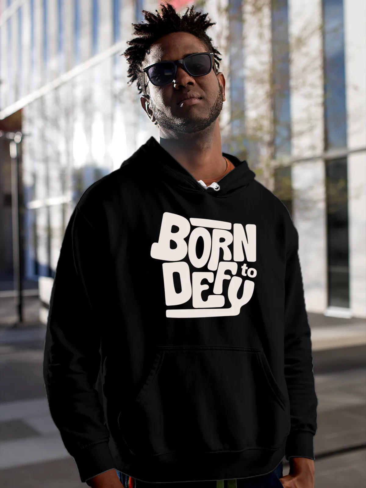 Model wearing Men's Black Hoodie Sweatshirt with 'Born To Defy' design, offering effortless style and premium comfort