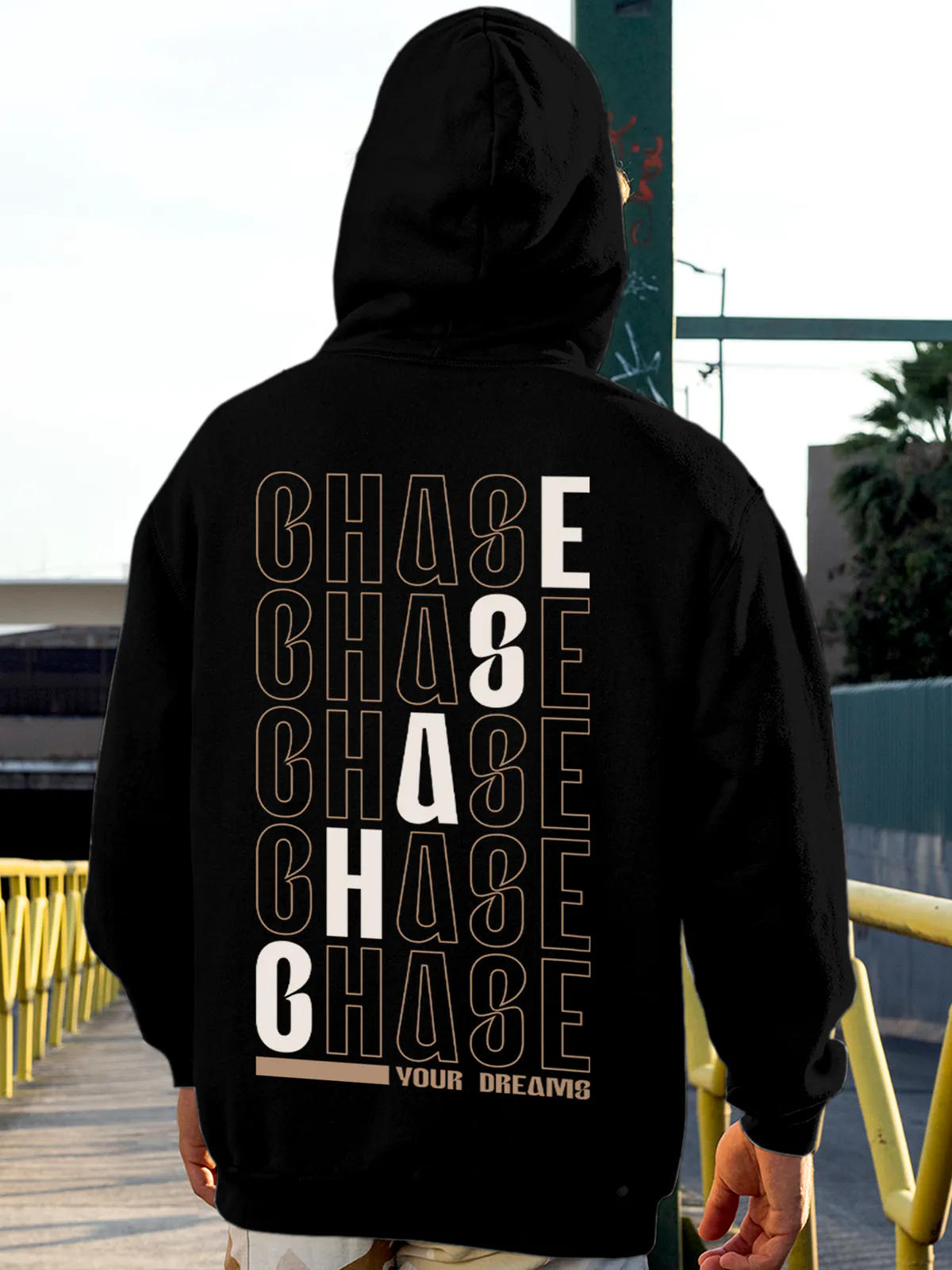 Model wearing Men's Black Hoodie Sweatshirt with 'Chase Your Dreams' design, offering effortless style and premium comfort