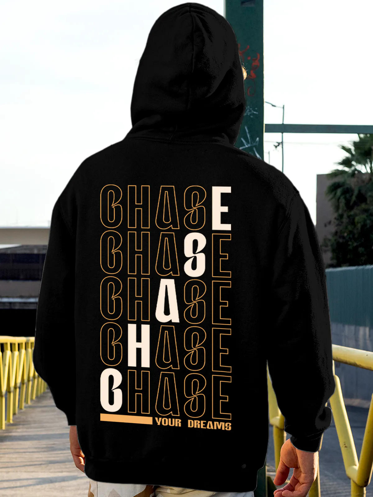 Model wearing Men's Black Hoodie Sweatshirt with 'Chase Your Dreams' design, offering effortless style and premium comfort
