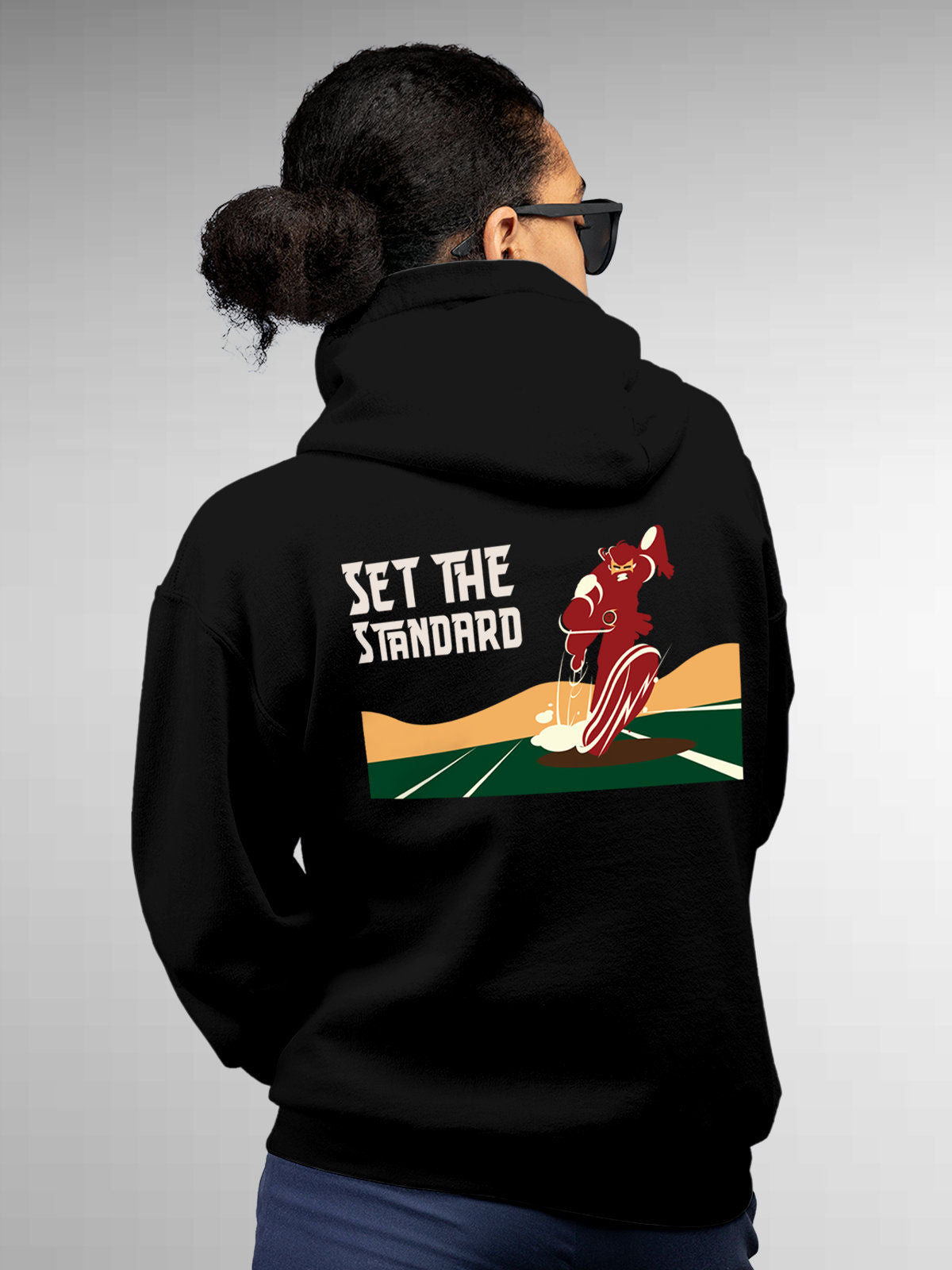 Model wearing Women's Black Hoodie Sweatshirt with 'Raise The Bar' design, offering effortless style and premium comfort