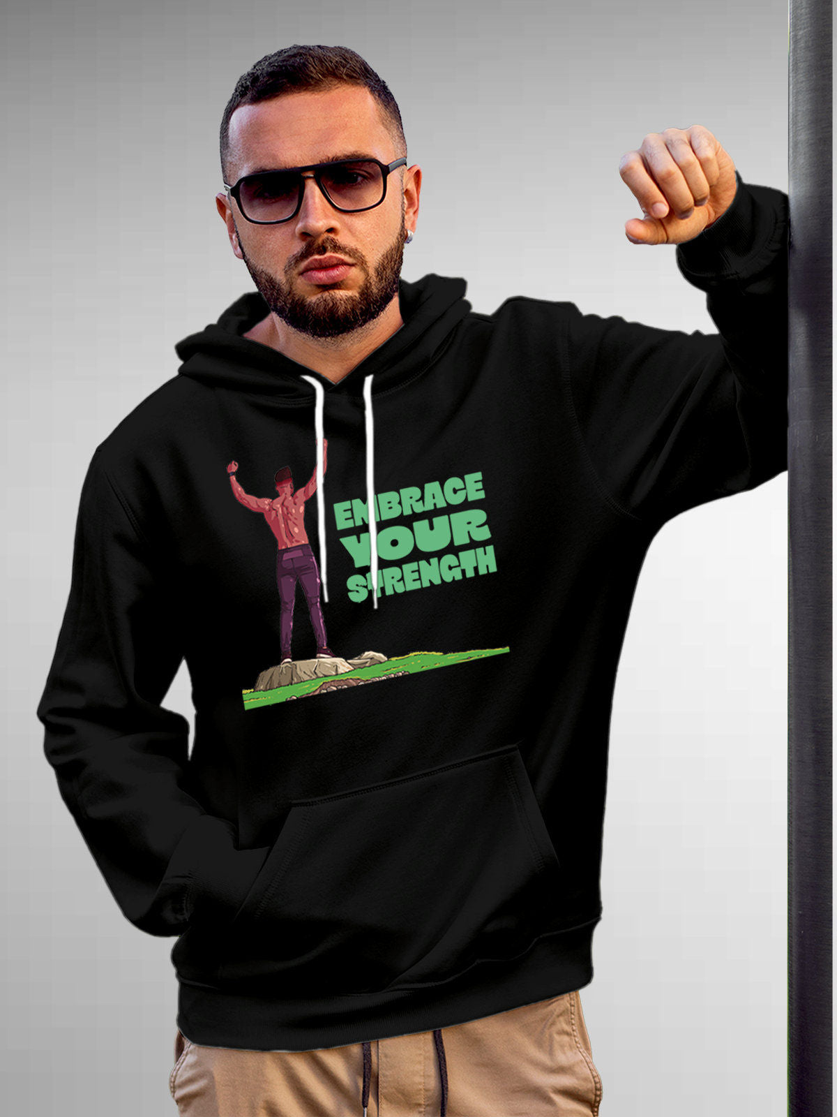 Model wearing Men's Black Hoodie Sweatshirt with 'Embrace Your Strength' design, offering effortless style and premium comfort
