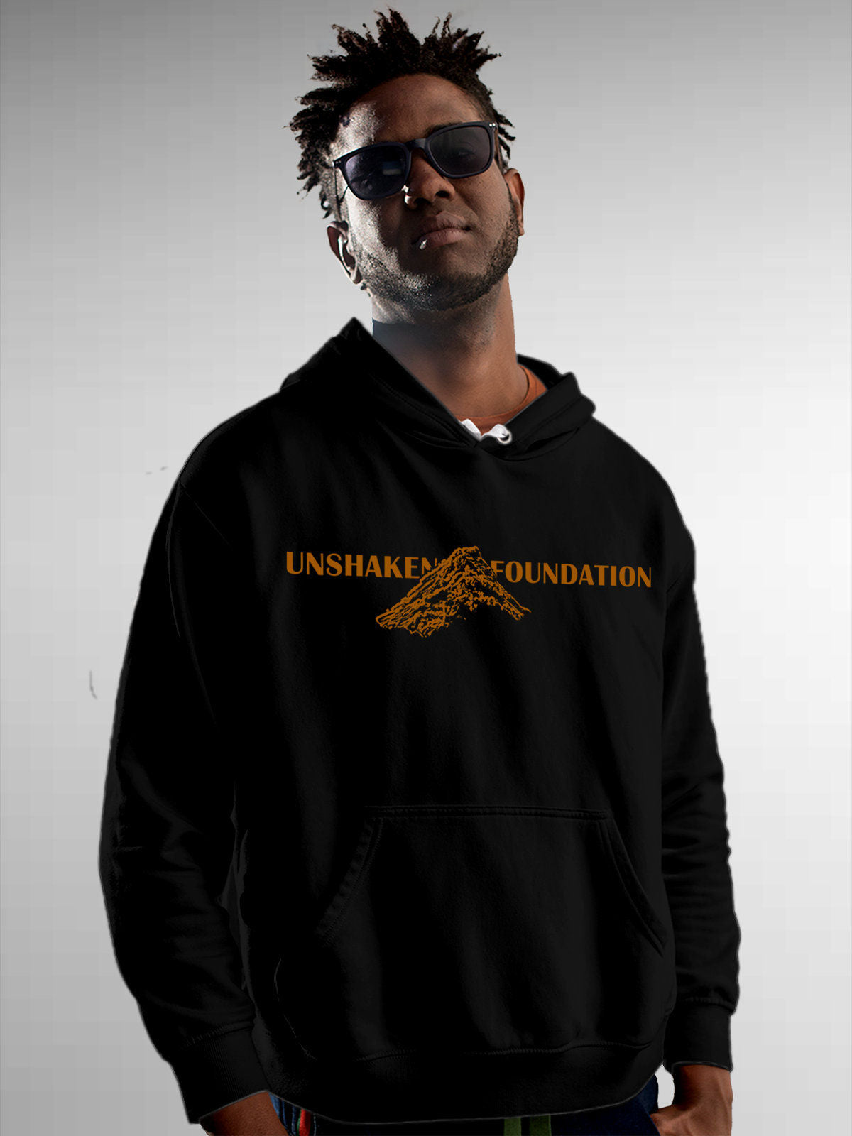 Model wearing Men's Black Hoodie Sweatshirt with 'Unshaken Foundation' design, offering effortless style and premium comfort