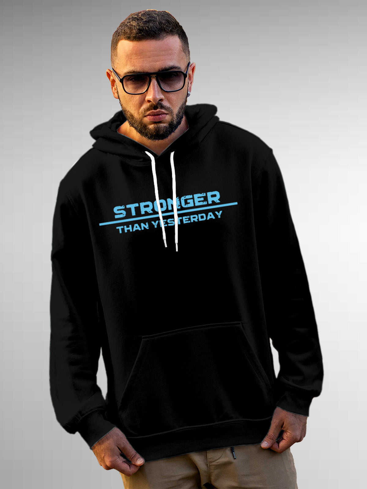 Model wearing Men's Black Hoodie Sweatshirt with 'Stronger Than Yesterday' design, offering effortless style and premium comfort