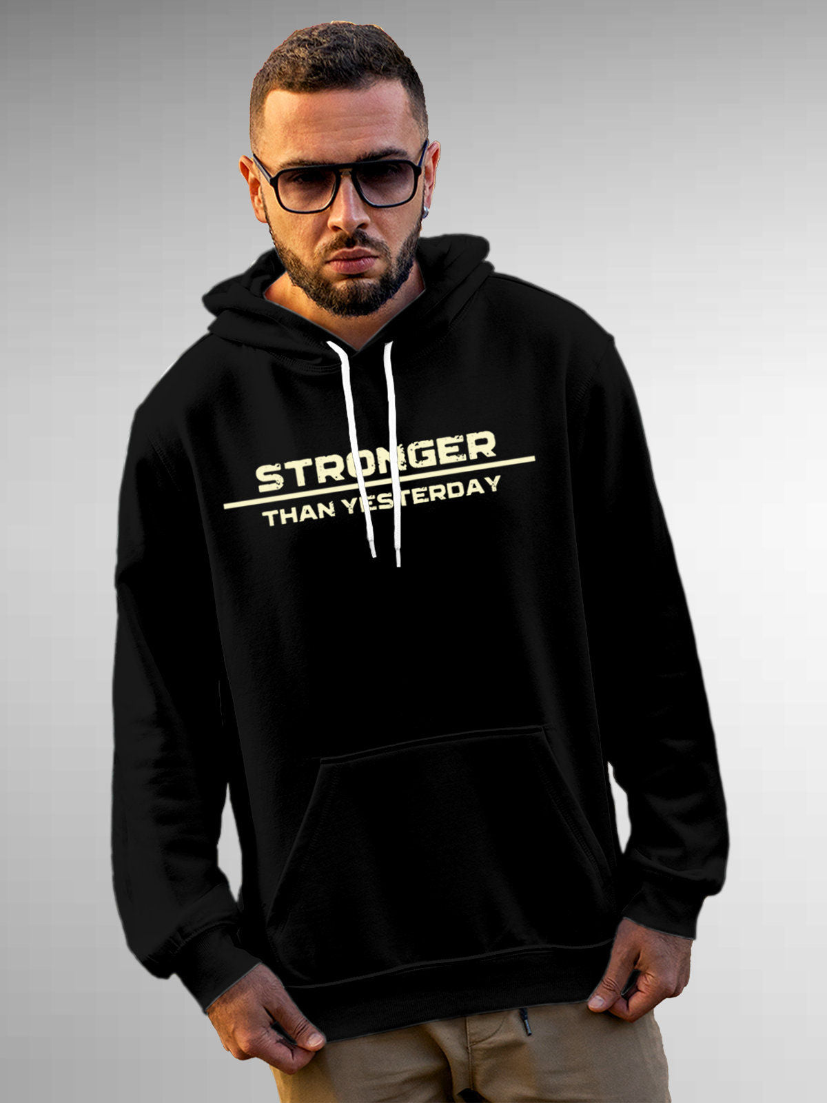 Model wearing Men's Black Hoodie Sweatshirt with 'Stronger Than Yesterday' design, offering effortless style and premium comfort