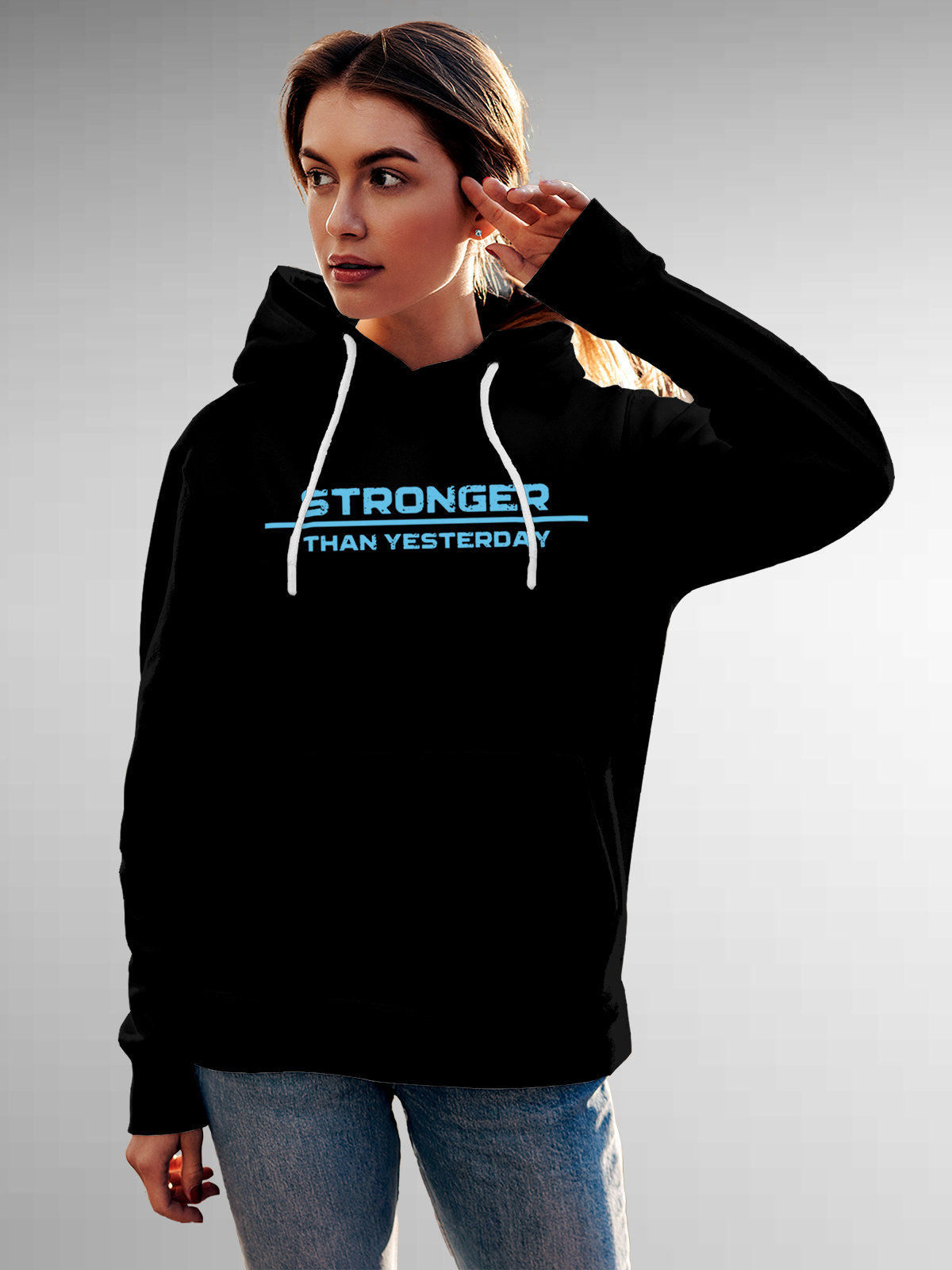 Model wearing Women's Black Hoodie Sweatshirt with 'Stronger Than Yesterday' design, offering effortless style and premium comfort