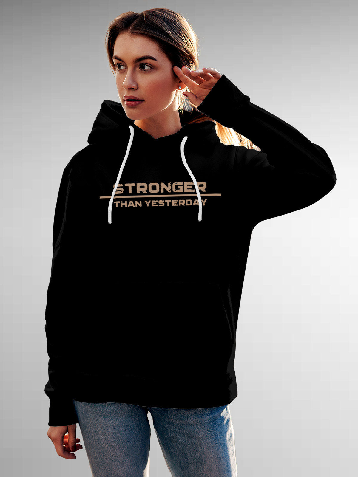 Model wearing Women's Black Hoodie Sweatshirt with 'Stronger Than Yesterday' design, offering effortless style and premium comfort