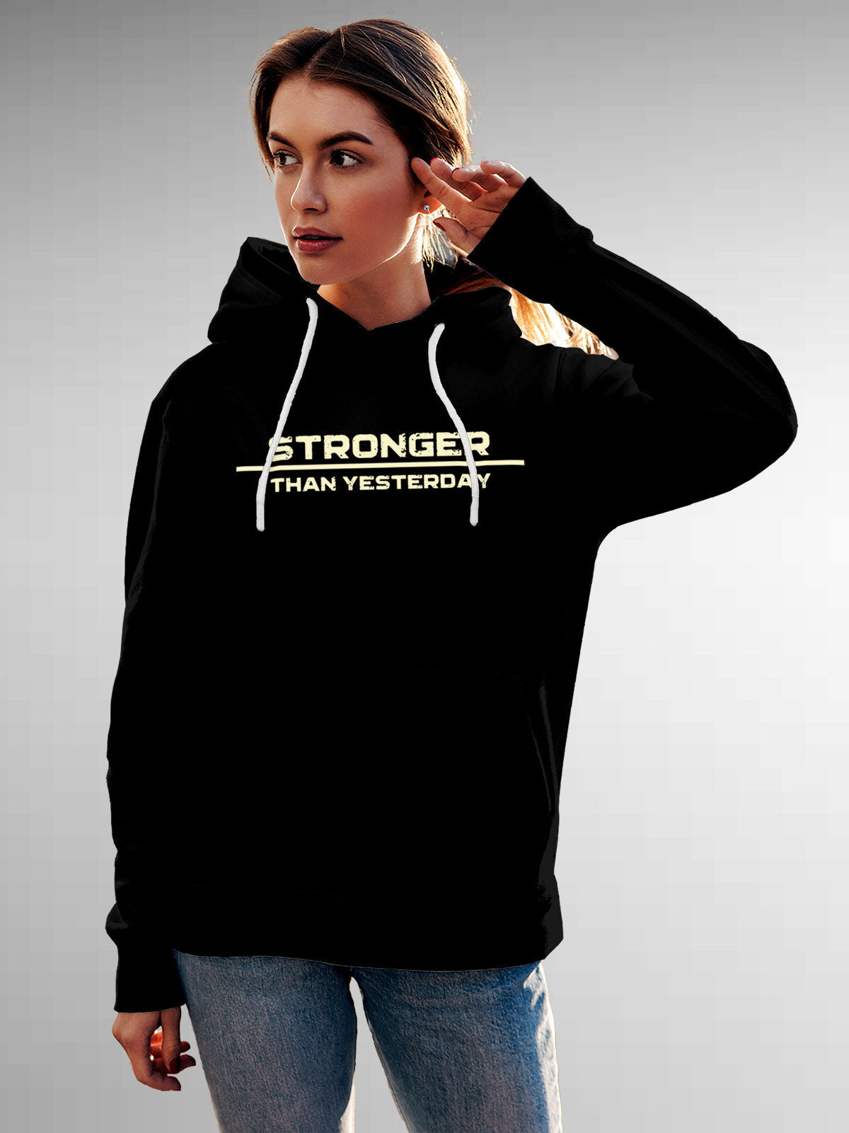 Model wearing Women's Black Hoodie Sweatshirt with 'Stronger Than Yesterday' design, offering effortless style and premium comfort