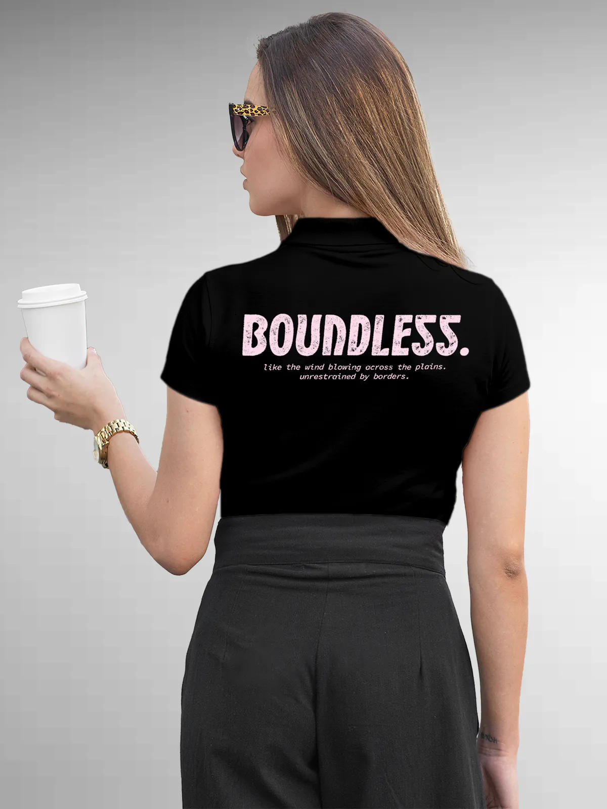 Model wearing Women's Black Collar T-shirt with a big, bold 'Boundless' design printed on the back, along with an insiprational text