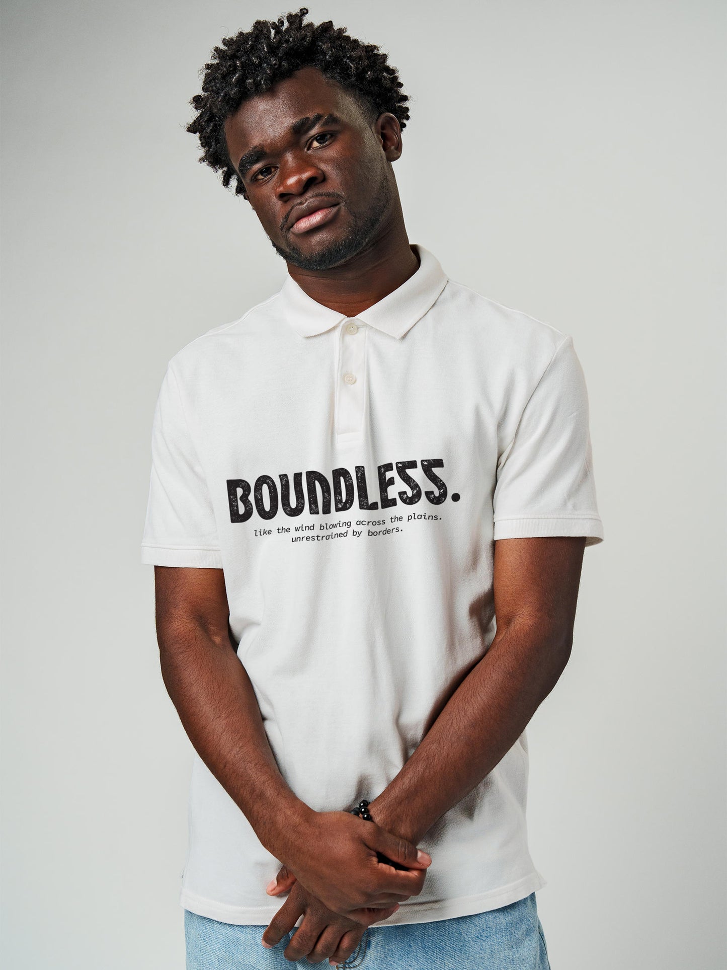 Model wearing Men's White Polo T-shirt with 'Free & Boundless' design, offering effortless style and premium comfort