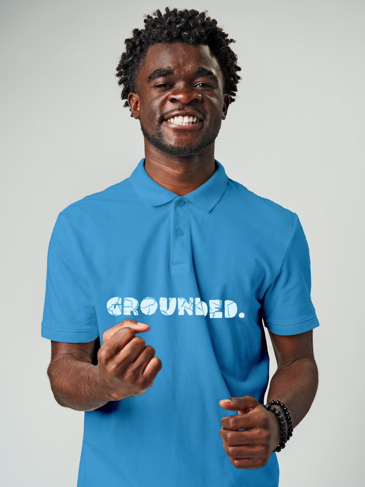 Model wearing Men's Blue Polo T-shirt with 'Grounded' design, offering effortless style and premium comfort