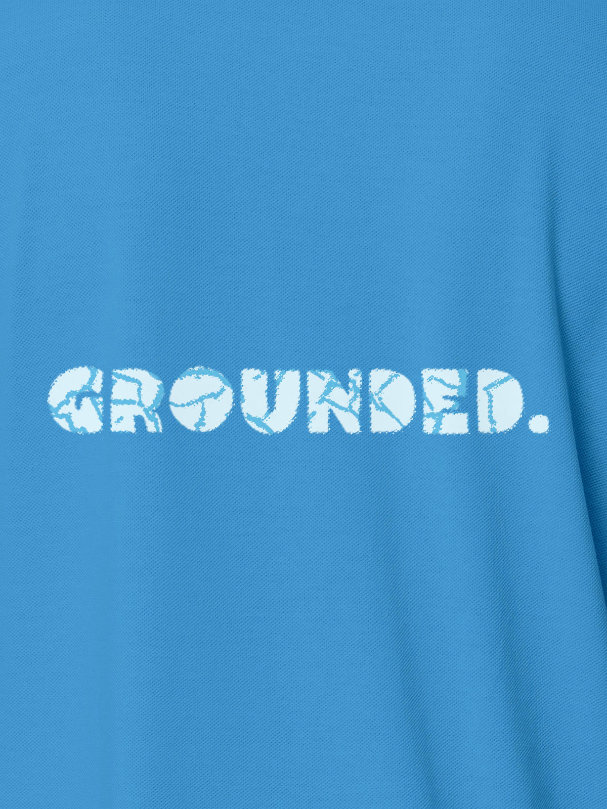 Close up of 'Grounded' design on Women's Blue Polo T-shirt, highlighting intricate details and vibrant print.