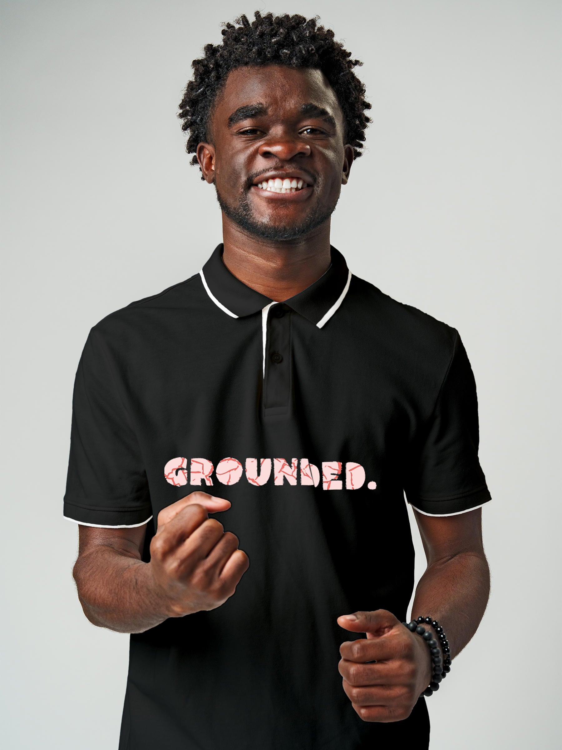 Model wearing Men's Dark Grey Polo T-shirt with 'Grounded' design, offering effortless style and premium comfort