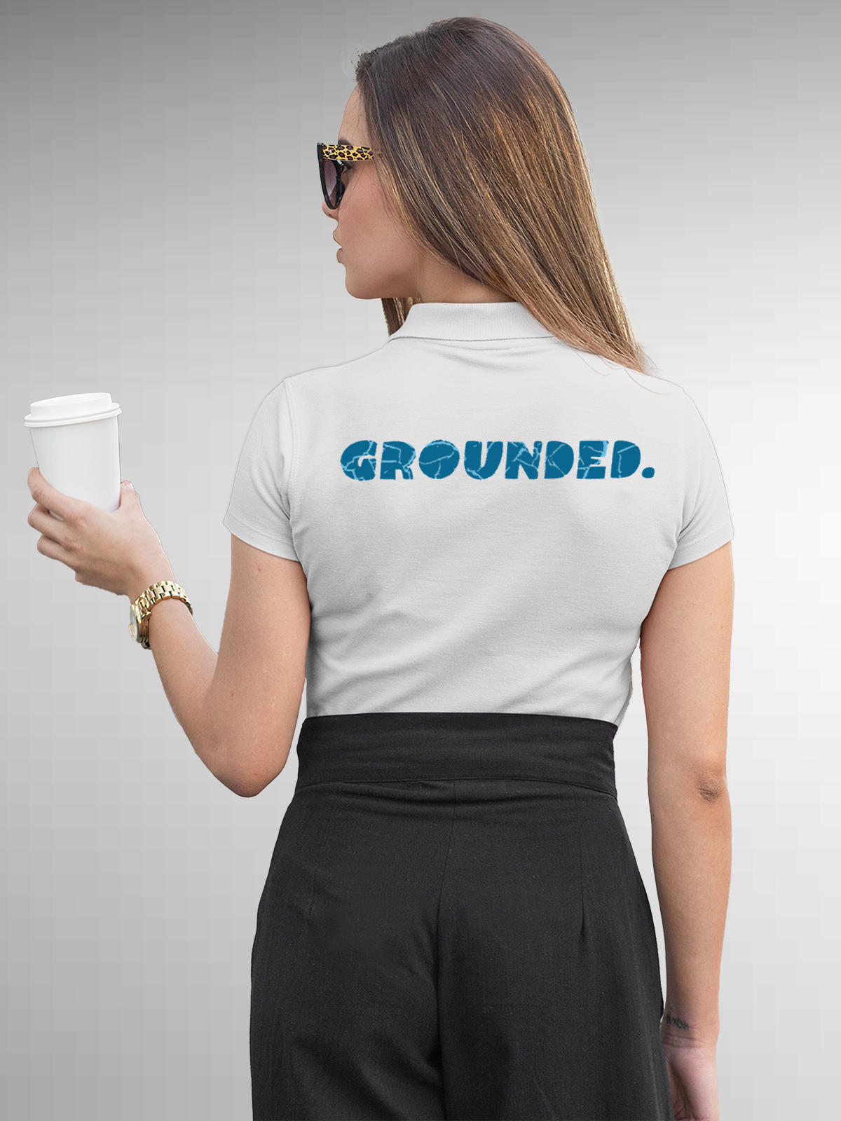 Model wearing Women's White Polo T-shirt with 'Grounded' design, offering effortless style and premium comfort