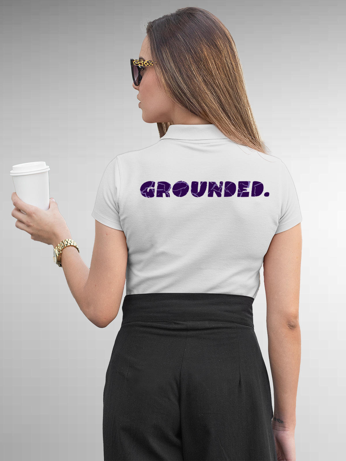 Model wearing Women's White Polo T-shirt with 'Grounded' design, offering effortless style and premium comfort