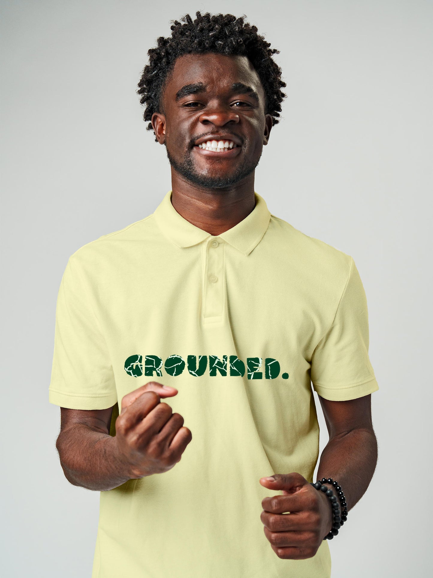 Model wearing Men's Yellow Polo T-shirt with 'Grounded' design, offering effortless style and premium comfort