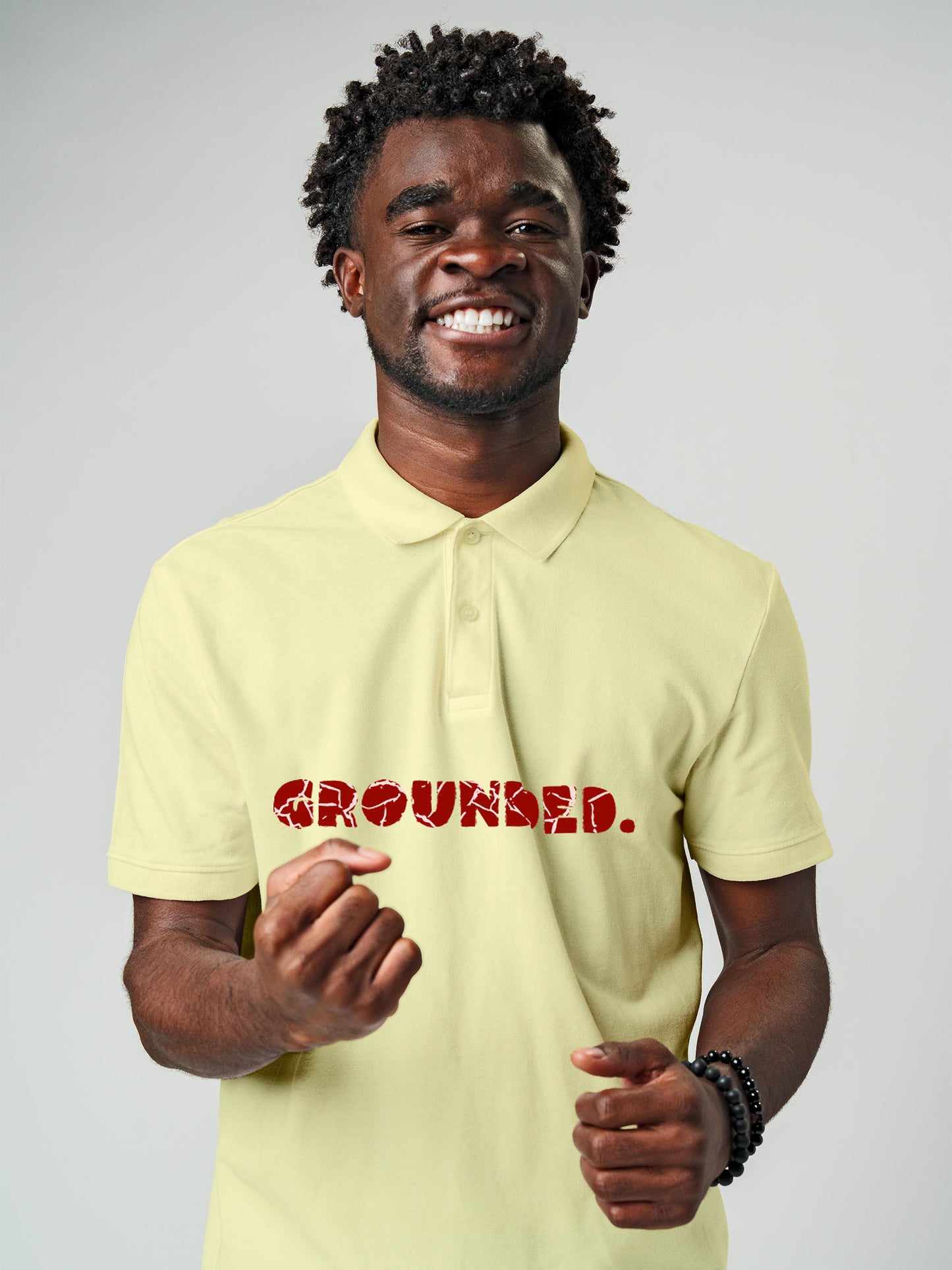 Model wearing Men's Yellow Polo T-shirt with 'Grounded' design, offering effortless style and premium comfort