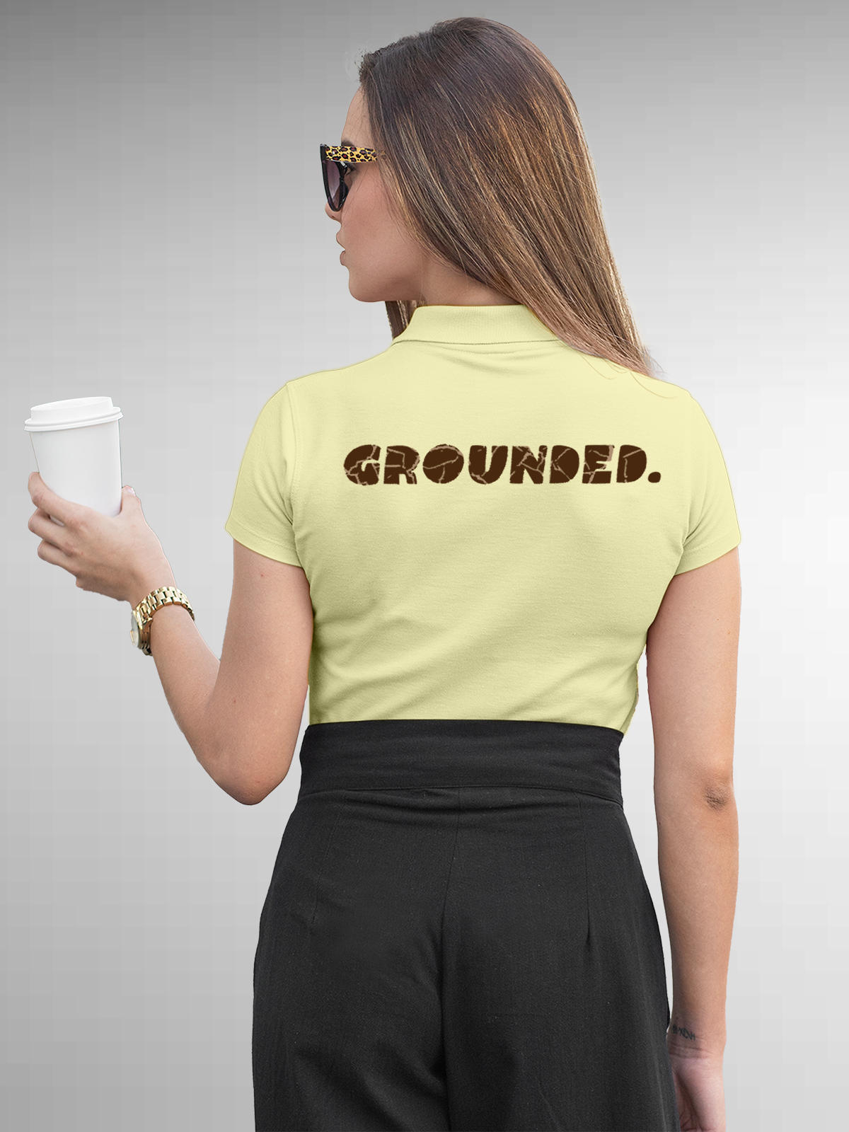 Model wearing Women's Yellow Polo T-shirt with 'Grounded' design, offering effortless style and premium comfort