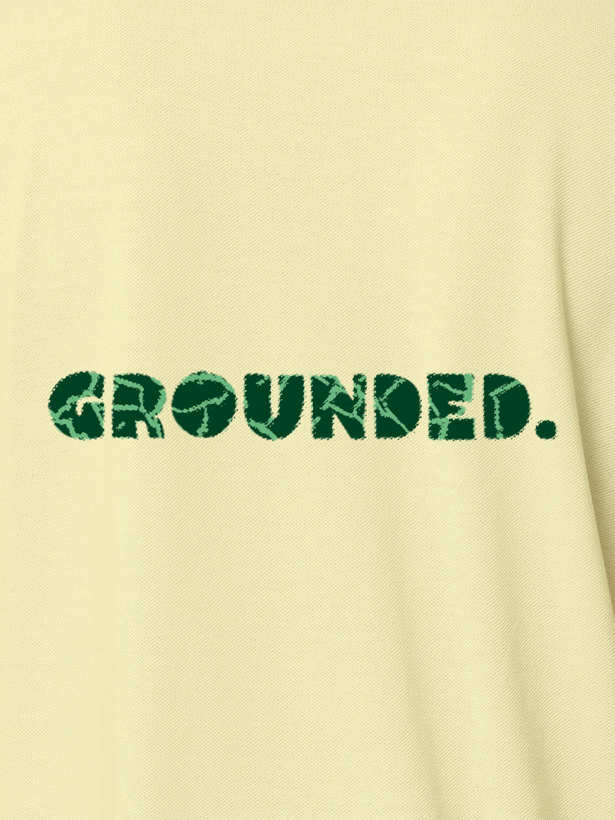 Close up of 'Grounded' design on Women's Yellow Polo T-shirt, highlighting intricate details and vibrant print.