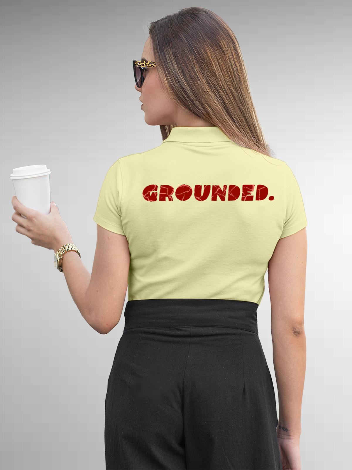 Model wearing Women's Yellow Polo T-shirt with 'Grounded' design, offering effortless style and premium comfort